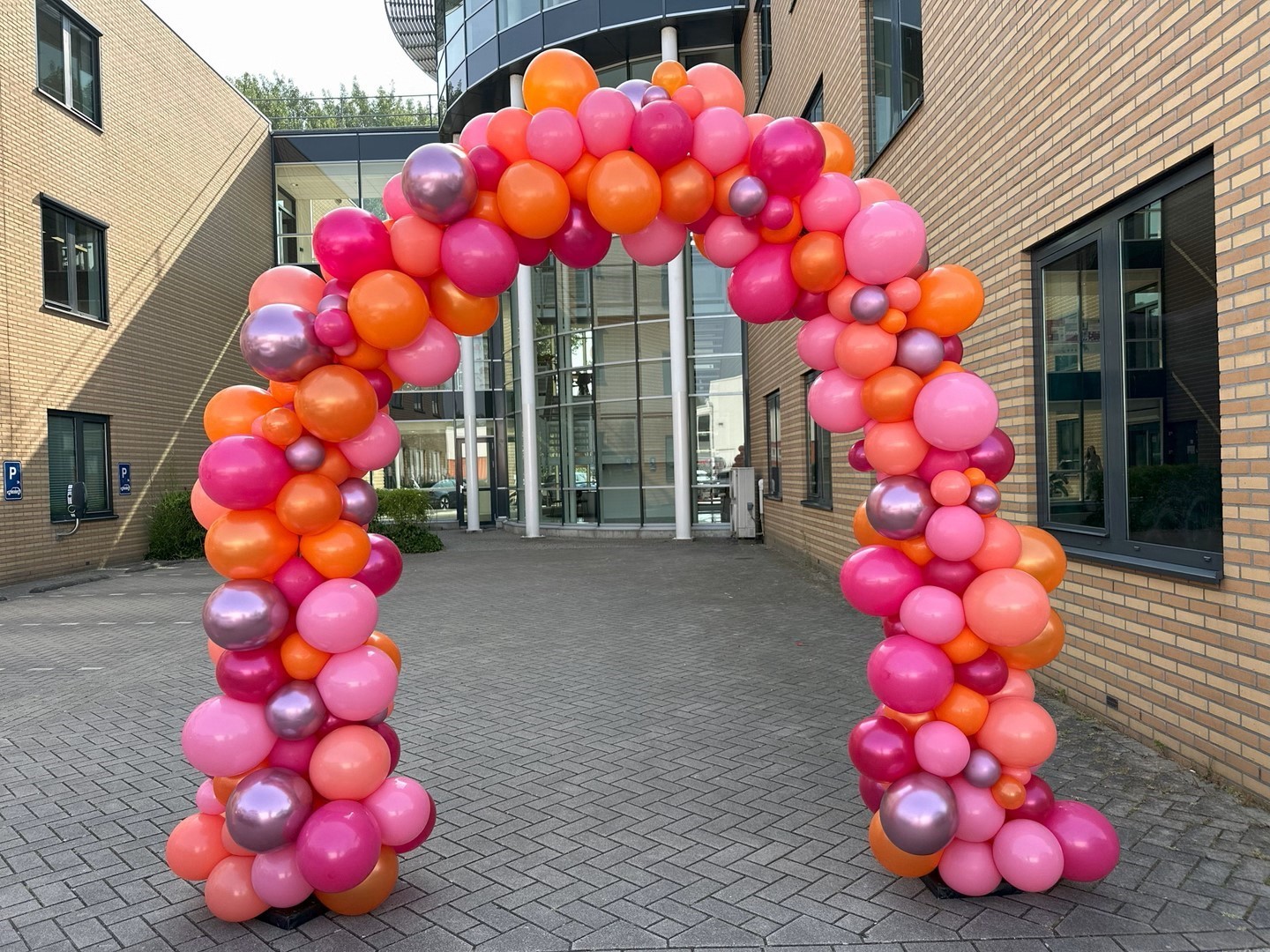 Ballonnenboog organisch samengesteld met verschillende maten en kleuren ballonnen