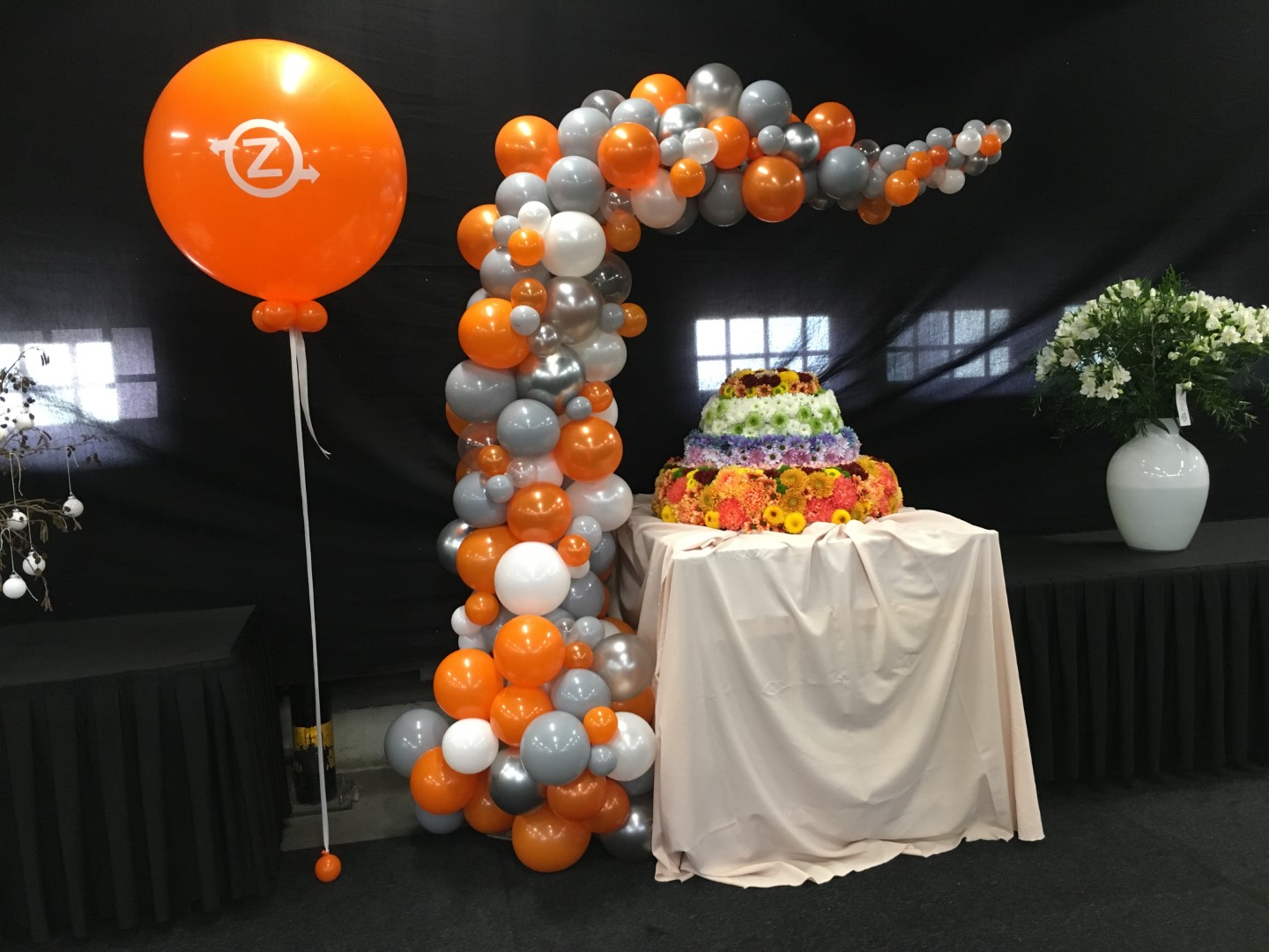 Halve Organische Boog met bedrukte reuze heliumballon geplaatst over een tafel ter promotie