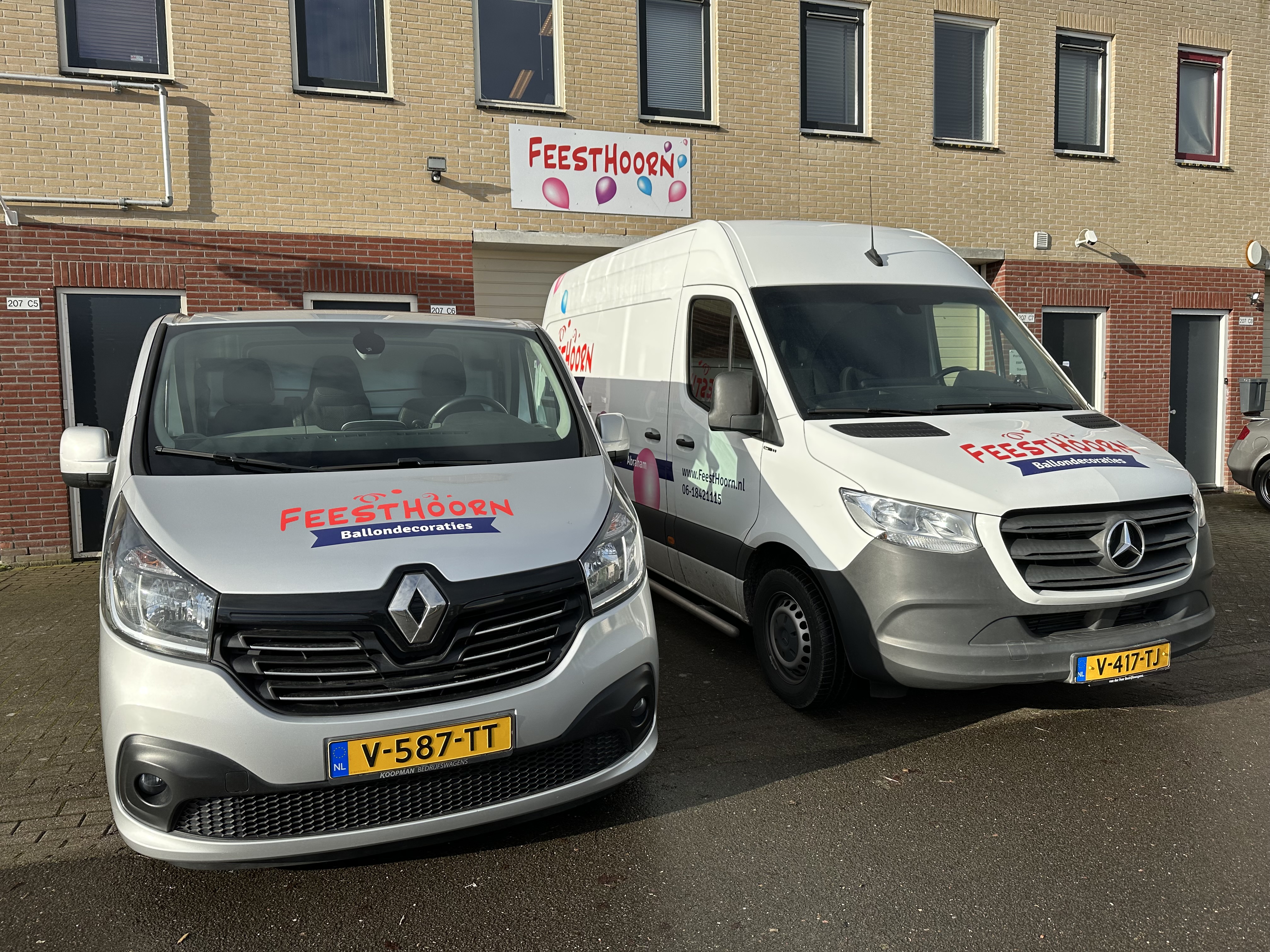 Bedrijfswagens van FeestHoorn voor het bedrijfspand geparkeerd