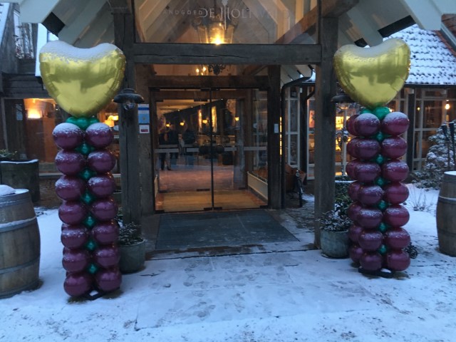 Ballonnenpilaren met gouden folieharten topballonnen in de sneeuw
